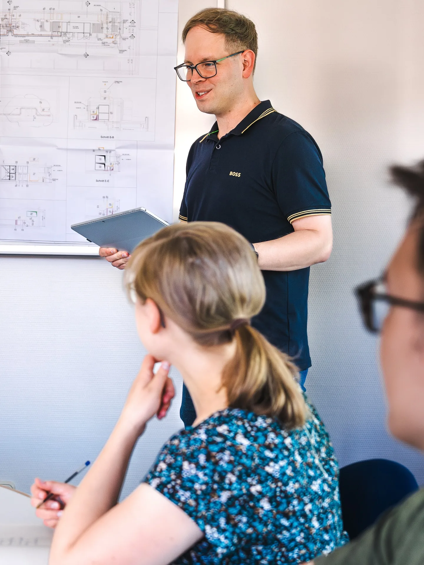 Ingenieur des Ingenieurbüros Meyer erläutert technische Pläne am Whiteboard
