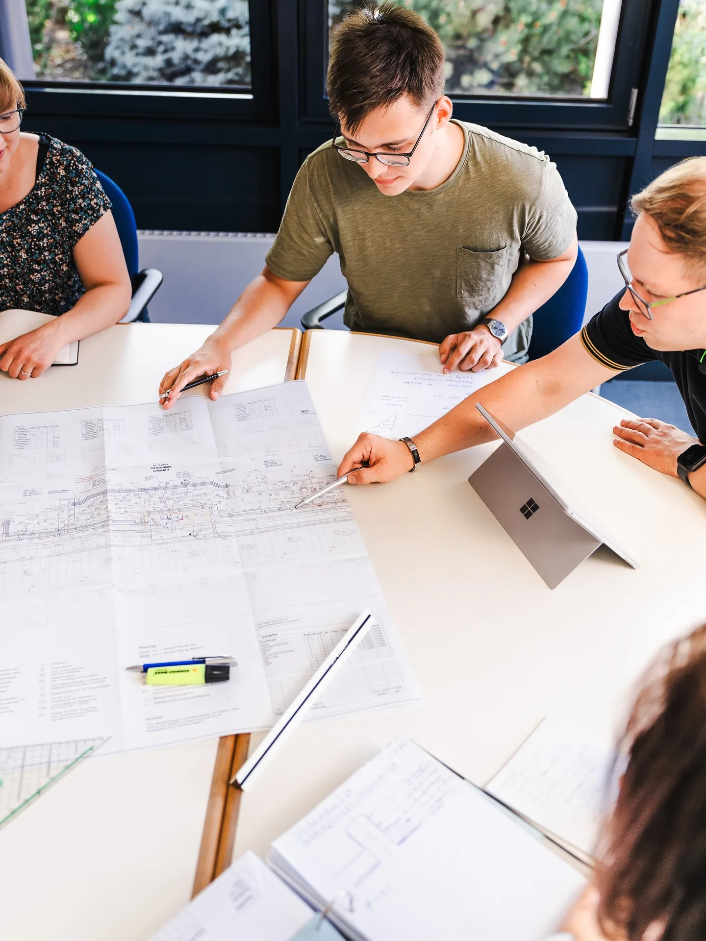 Das Team des Ingenieurbüros Meyer bespricht gemeinsam Baupläne am Besprechungstisch in Braunschweig